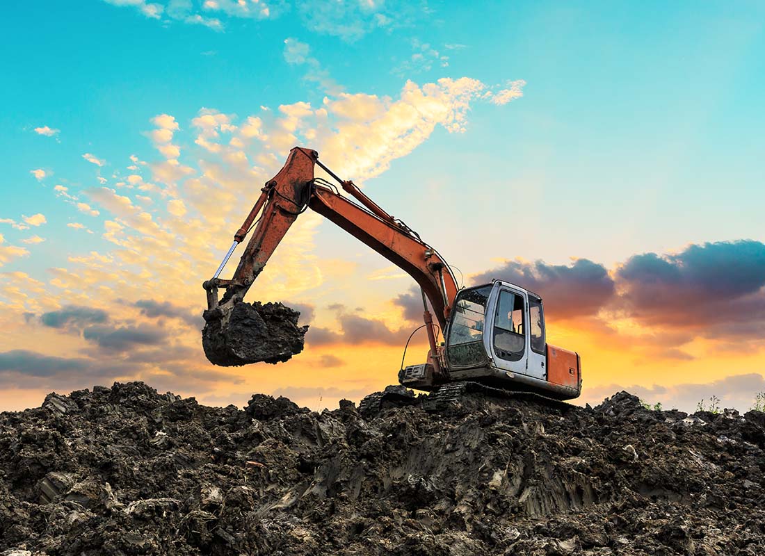 Excavation Contractor Insurance - Stylized Image of an Excavator Working at Construction Site on Summer Day at Sunset